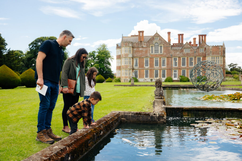 A family looking at a pond by Burton Agnes hall